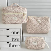 1PC Pink Strawberry Women Cosmetic Quilted Bag displayed in three sizes on a white shelf with storage boxes.