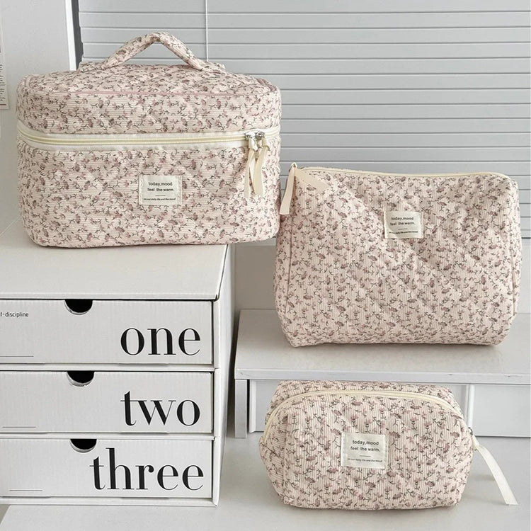 1PC Pink Strawberry Women Cosmetic Quilted Bag displayed in three sizes on a white shelf with storage boxes.