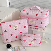 1PC Pink Strawberry Women Cosmetic Quilted Bag set displayed on a countertop with beauty products.